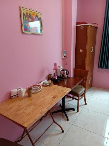 a wooden table in a room with a pink wall at HangNga homestay - hotel in Phủ Từ Sơn