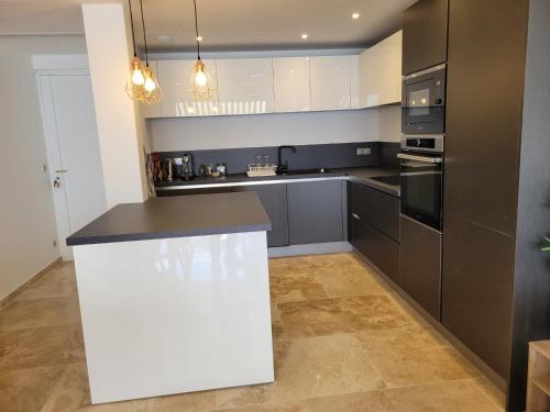 a kitchen with black and white cabinets and a counter at Splendide Vue Mer in Sainte-Maxime