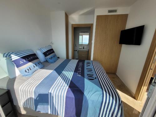 a bedroom with a bed with a blue and white comforter at Splendide Vue Mer in Sainte-Maxime