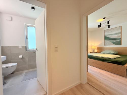 a bedroom with a bed and a bathroom with a toilet at Suite Carpe Diem in Uhldingen-Mühlhofen