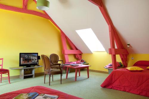une chambre avec un lit et une télévision dans une pièce dans l'établissement Logis hôtel Ô en Couleur, à Oucques