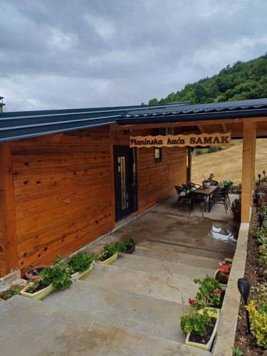 a building with a patio with a table and chairs at Planinska kuća SAMAK in Sarajevo