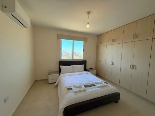 a bedroom with a large bed and a window at Sunrise Palette Suites in Larnaca