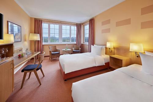 Una cama o camas en una habitación de Golf- und Sporthotel Wiesensee