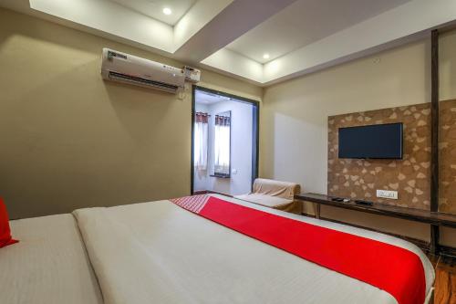 a bedroom with a large bed with a red blanket at Capital O SKY GRAND in Hyderabad