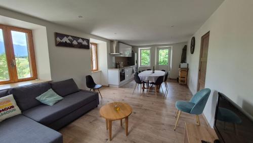 un salon avec un canapé et une table dans l'établissement La Ferme Lazare - maison entièrement rénovée, à Saint-Pierre-dʼAlbigny