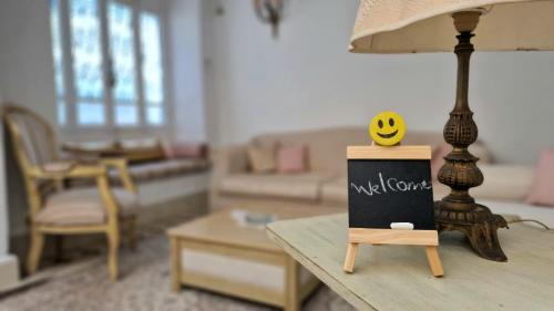 a table with a lamp with a smiley face on it at Dar El Aalia Sea View Stay in Iconic Sidi Bou Saïd in Sidi Bou Saïd