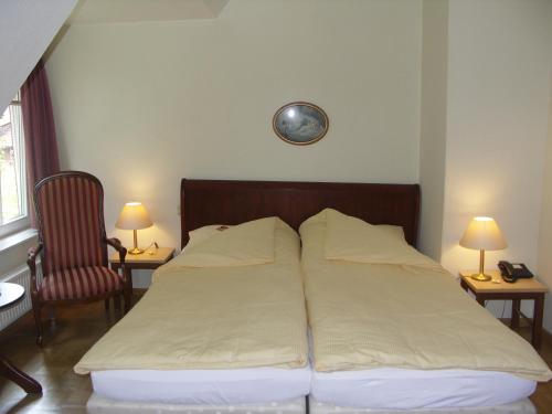a bedroom with two beds and a clock on the wall at Dreimädelhaus - Kirchseelte in Kirchseelte