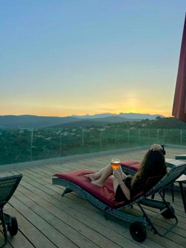 a woman laying on a bed with a cup of coffee at Hotel Carre Noir in Porto-Vecchio