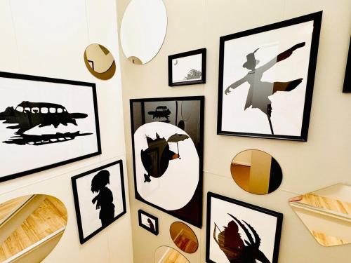 a wall with framed pictures on a wall at SETO8 House in Seto