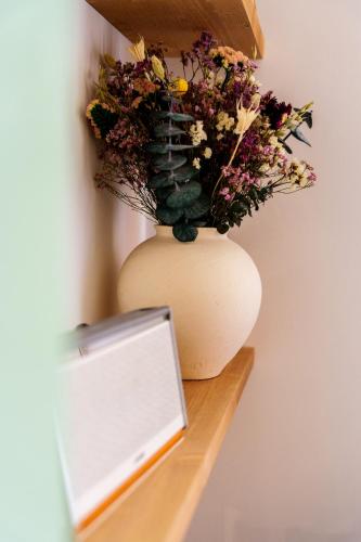 a vase with flowers in it sitting on a shelf at IMROF - Mountain Lodge in Escarrilla