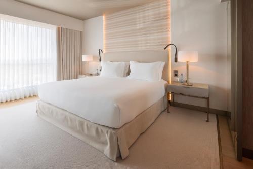 a bedroom with a large white bed and a window at EPIC SANA Marquês Hotel in Lisbon