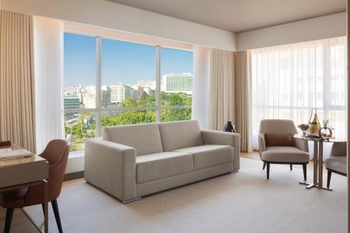 a living room with a couch and a large window at EPIC SANA Marquês Hotel in Lisbon