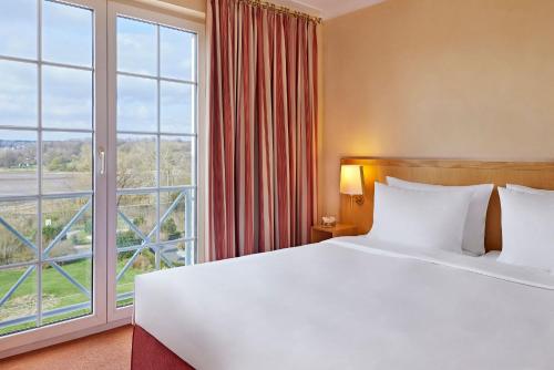 Una cama o camas en una habitación de Golf- und Sporthotel Wiesensee