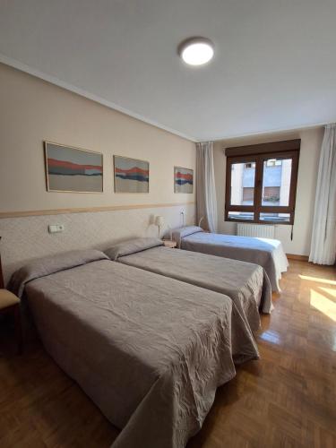 a hotel room with two beds and a window at Arriondas Toyos A in Arriondas