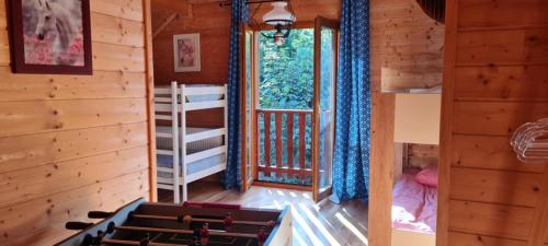 a room in a cabin with a bed and a window at gîte des 1000 étangs in Saint-Bresson