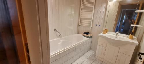 a white bathroom with a tub and a sink at gîte des 1000 étangs in Saint-Bresson