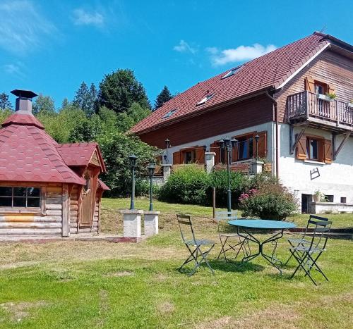 a house with a table and chairs in the yard at gîte des 1000 étangs in Saint-Bresson