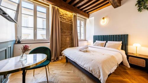 - une chambre avec un grand lit et une table en verre dans l'établissement L'Écrin des Vignes - Appartement de Charme en Hyper-Centre, à Dijon