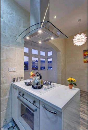 a kitchen with a island with a stove top oven at Seafront 1 bedroom Maisonette in Kalkara