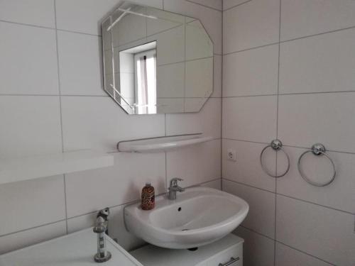 a white bathroom with a sink and a mirror at 5 Personen Ferienhaus mit Kaminofen in erster Reihe hinterm Deich in Otterndorf in Otterndorf