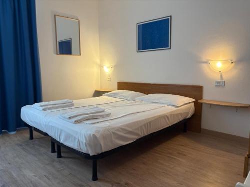 a bedroom with a bed with two tables and a mirror at Hotel Villa Al Vento in Nago-Torbole