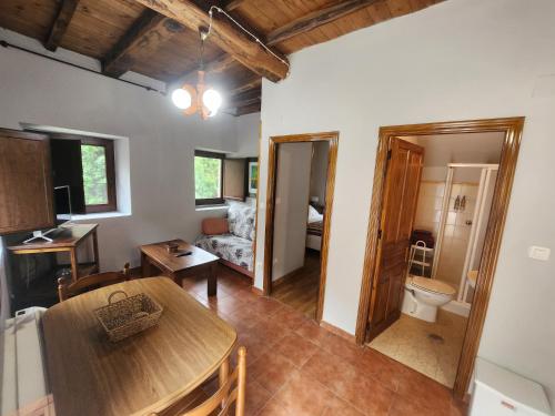 - un salon avec une table et une chambre avec un canapé dans l'établissement Valles del Narcea, Apartamentos Rurales, à Cangas del Narcea