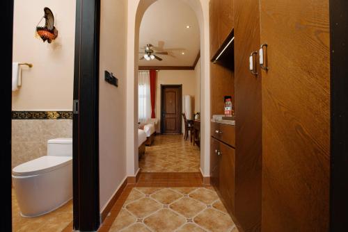 a hallway of a bathroom with a toilet and a sink at Karamay West Wuzhen Tancheng Hotel in Urho