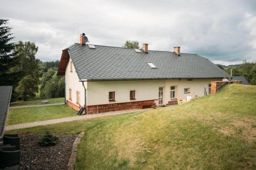 a white house on top of a grassy hill at Holiday Home Elizabeth in Svojek