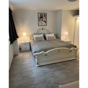 a bedroom with a large bed with two lamps on it at Lägenhet på landet nära stan in Jonsered