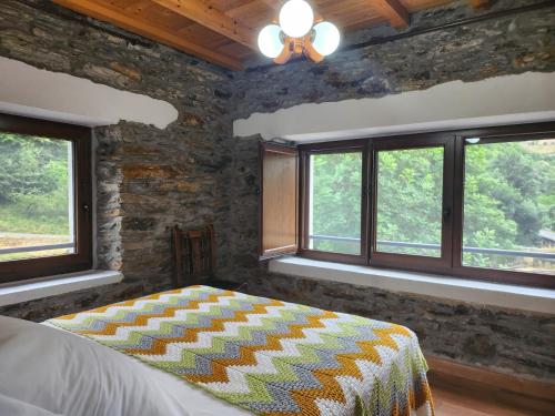 une chambre avec un lit dans une pièce avec des fenêtres dans l'établissement Valles del Narcea, Apartamentos Rurales, à Cangas del Narcea