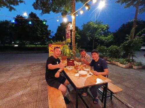 a group of men sitting at a table at night at HangNga homestay - hotel in Phủ Từ Sơn