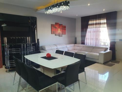 a living room with a table and a couch at Modern, stylish & comfortable 3 bedroom apartment with jacuzzi and private yard with barbeque in Mellieħa