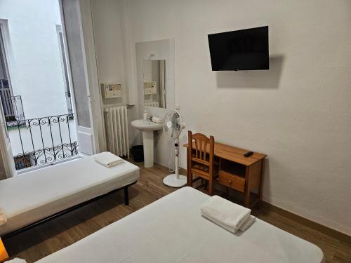 马德里米拉尔瓦旅馆的有两张床、一张桌子和一台电视的房间