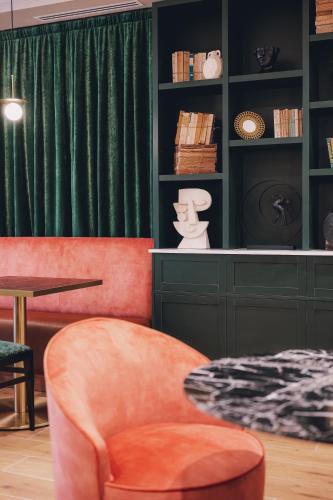 ein Wohnzimmer mit einem grünen Vorhang und einem Stuhl in der Unterkunft Maison Orphée in Paris