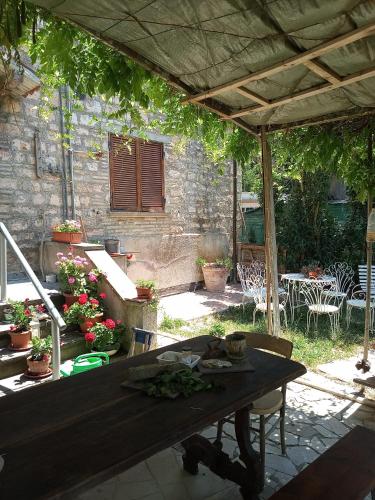 a patio with a table and chairs and a building at Lavecchiaconcia -de oude leerlooilerij Casa Vacanze Zommer Vakantiehuis in Cagli