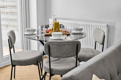 a dining room table with chairs and a table with food on it at NEW! Sleek & Spacious House by Clarendon Stays, Driveway Parking, WiFi, Smart TV in Allesley