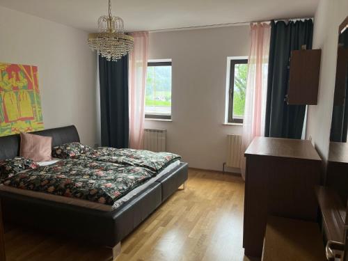 a bedroom with a bed and a table and windows at Ferienwohnung Gegenhaus in Weberstorf