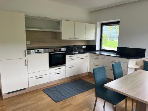 a kitchen with white cabinets and a table with chairs at Ferienwohnung Gegenhaus in Weberstorf