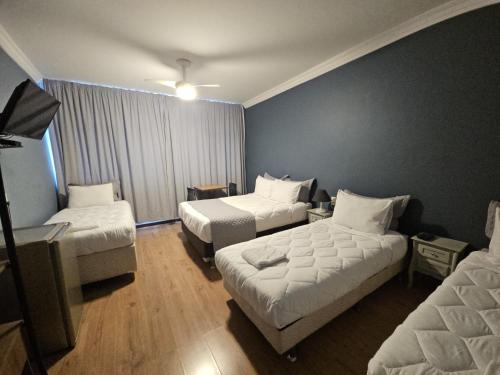 a hotel room with two beds and a couch at Hospedaria Santiago in Teresópolis