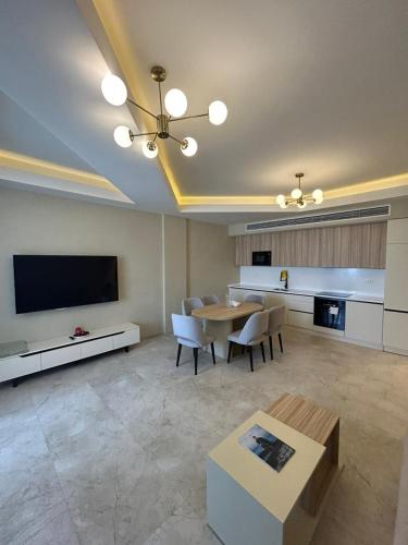 a large living room with a table and a tv at Sea Breeze The Grand 347 in Nardaran