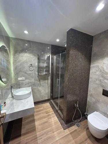 a bathroom with a toilet and a sink and a shower at Sea Breeze The Grand 347 in Nardaran