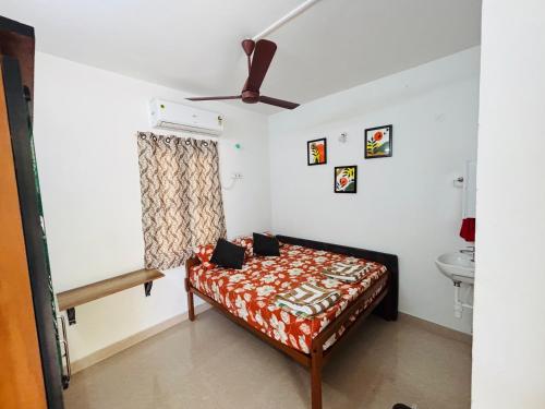 a bedroom with a bed and a ceiling fan at SHI's Agam Bed & Breakfast at Chennai in Chennai