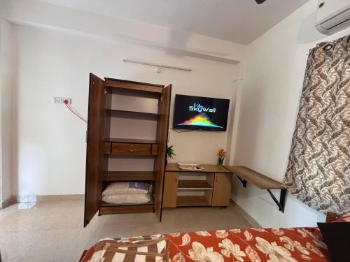 a room with a desk and a tv on the wall at SHI's Agam Bed & Breakfast at Chennai in Chennai