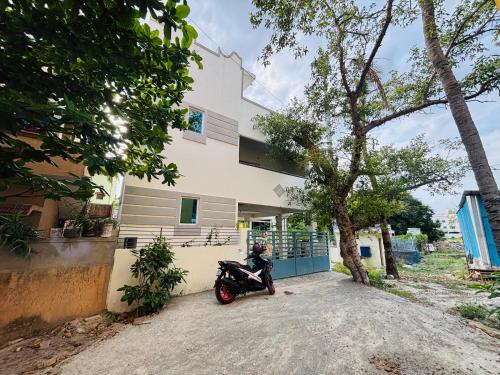 a person sitting on a motorcycle in front of a building at SHI's Agam Bed & Breakfast at Chennai in Chennai