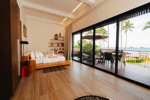 a bedroom with a bed and a view of the ocean at Nacpan Beach Glamping Managed by H Hospitality Group in El Nido