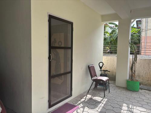 a chair sitting in front of a house with a door at SHI's Agam Bed & Breakfast at Chennai in Chennai