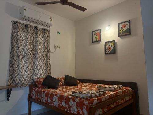 a bedroom with a bed and a ceiling fan at SHI's Agam Bed & Breakfast at Chennai in Chennai