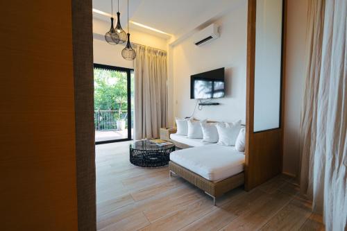 a room with a bed and a couch and a window at Nacpan Beach Glamping Managed by H Hospitality Group in El Nido