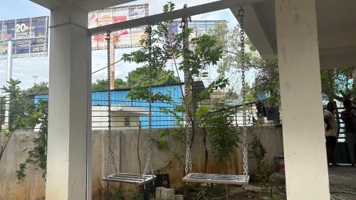 two benches chained to a fence with a tree at SHI's Agam Bed & Breakfast at Chennai in Chennai